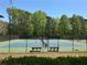 Well-maintained tennis court with benches, surrounded by lush greenery at Lost Forest at 2612 Peterboro Row, Marietta, GA 30062