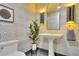 Stylish powder room featuring geometric wallpaper, pedestal sink, modern lighting, and a decorative plant for added charm at 700 Park Regency Ne Pl # 805, Atlanta, GA 30326