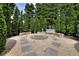 Secluded fire pit area with gravel, stone benches, and mature trees providing privacy at 700 Park Regency Ne Pl # 805, Atlanta, GA 30326