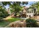 Well-maintained backyard featuring a patio, deck, mature trees, and landscaped areas at 10530 Tuxford Dr, Alpharetta, GA 30022