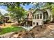 Lush backyard with patio, wood deck, stone accents, and mature trees at 10530 Tuxford Dr, Alpharetta, GA 30022