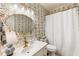 Charming bathroom with patterned wallpaper, white vanity, decorative mirror, and shower with scalloped curtain at 10530 Tuxford Dr, Alpharetta, GA 30022