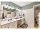 Bathroom featuring double sinks, white cabinets, and a tile floor at 10530 Tuxford Dr, Alpharetta, GA 30022