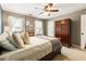 Bedroom with neutral walls, two windows, and a dark wood wardrobe at 10530 Tuxford Dr, Alpharetta, GA 30022