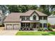 Charming two-story home with a well-manicured lawn, a welcoming porch, and a two car garage at 10530 Tuxford Dr, Alpharetta, GA 30022
