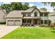 Charming two-story home features a well-manicured lawn, stone accents, and a welcoming front porch perfect for relaxing at 10530 Tuxford Dr, Alpharetta, GA 30022