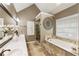 Bright bathroom with double sinks, garden tub and glass shower, and decorative wall art at 10530 Tuxford Dr, Alpharetta, GA 30022