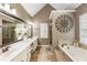 Bright bathroom with double sinks, garden tub and glass shower, and decorative wall art at 10530 Tuxford Dr, Alpharetta, GA 30022