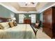 Bedroom featuring a decorative tray ceiling, a wooden bed frame, and a seating area at 10530 Tuxford Dr, Alpharetta, GA 30022