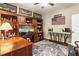 Spacious home office featuring custom built-ins, wood desk, and decorative accents on a patterned rug at 10530 Tuxford Dr, Alpharetta, GA 30022