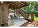 Cozy covered patio features a dining set and stairs leading to an upper level deck at 10530 Tuxford Dr, Alpharetta, GA 30022