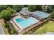 Aerial view of community pool and clubhouse, surrounded by manicured landscaping and featuring tennis courts at 10530 Tuxford Dr, Alpharetta, GA 30022