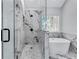 This contemporary bathroom features glass enclosed shower and soaking tub surrounded by elegant marble tiling at 2169 Wingfoot Pl, Decatur, GA 30035