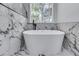This modern tub is set in front of a bright window with marble surround at 2169 Wingfoot Pl, Decatur, GA 30035