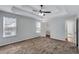 Spacious bedroom featuring neutral walls, plush carpet, tray ceilings, access to the bathroom, and closet at 2169 Wingfoot Pl, Decatur, GA 30035