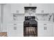 Modern kitchen features white cabinets, black appliances and a gas range with black hardware at 2169 Wingfoot Pl, Decatur, GA 30035