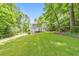 Expansive lawn behind the home surrounded by lush trees at 405 W Leslie Ct, Woodstock, GA 30188