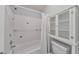 Bathroom features a tub with tile surround and a white cabinet at 405 W Leslie Ct, Woodstock, GA 30188