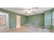 Green bedroom with neutral carpet, ceiling fan, and view of hall at 405 W Leslie Ct, Woodstock, GA 30188