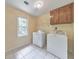 Functional laundry room with tile floors, a window, and included washer and dryer at 405 W Leslie Ct, Woodstock, GA 30188