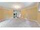 Bright living room featuring neutral carpet, light-yellow walls, and an elegant chandelier at 405 W Leslie Ct, Woodstock, GA 30188