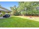 Green backyard featuring mature trees, a fire pit with pavers, and a covered patio with outdoor furniture at 456 Rockford Sw Pass, Marietta, GA 30064
