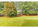 Lush backyard featuring a well-maintained lawn, privacy fence, and mature trees, creating a serene outdoor space at 456 Rockford Sw Pass, Marietta, GA 30064