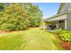 Expansive backyard featuring a manicured lawn, a covered patio, and lush landscaping with mature trees at 456 Rockford Sw Pass, Marietta, GA 30064