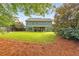 Beautiful backyard showcasing a large green lawn, mature trees, and the rear of the house with a covered patio at 456 Rockford Sw Pass, Marietta, GA 30064