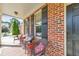 Comfortable front porch with wicker seating, brick detailing, and a view of the front yard and driveway at 456 Rockford Sw Pass, Marietta, GA 30064