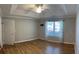Spacious bedroom with hardwood floors, tray ceiling, ceiling fan, and large window allowing ample natural light at 804 Village Pl, Loganville, GA 30052