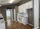 Bright kitchen featuring white cabinets, stainless appliances, and stylish wood-look flooring at 804 Village Pl, Loganville, GA 30052