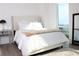Bright bedroom with a large window, white bedding and wooden floors at 2870 Pharr Court South Nw # 2507, Atlanta, GA 30305