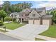 Spacious brick home featuring a three-car garage and an expansive driveway at 508 Highland Dr, Woodstock, GA 30188