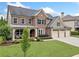 Charming two-story brick home with a well-maintained lawn and three-car garage at 508 Highland Dr, Woodstock, GA 30188