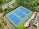 Aerial view of the community tennis courts featuring blue courts, green surroundings, and landscaping at 508 Highland Dr, Woodstock, GA 30188