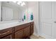 Bright bathroom featuring a white vanity, a dark wood cabinet, and a large mirror at 508 Highland Drive Dr, Woodstock, GA 30188