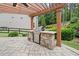 Covered outdoor kitchen includes a stone counter and stainless steel grill at 508 Highland Drive Dr, Woodstock, GA 30188