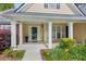 Inviting front porch with classic columns, surrounded by colorful landscaping, creating a warm and welcoming entrance at 726 Sunset Ridge Ln, Lawrenceville, GA 30045
