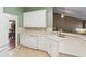 Functional kitchen with white cabinets, tile backsplash, and access to adjacent dining area at 726 Sunset Ridge Ln, Lawrenceville, GA 30045