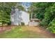 Large backyard featuring green grass, mature trees, a wooden fence, and storage building at 802 Bluff Pl, Woodstock, GA 30188