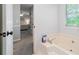 Bathroom with soaking tub and view to bedroom offers a luxurious retreat, enhanced by natural light at 802 Bluff Pl, Woodstock, GA 30188