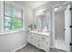 Bathroom with white vanity, framed mirror, and natural light from window creating a clean and inviting space at 802 Bluff Pl, Woodstock, GA 30188