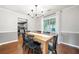 Dining room with wooden table, black chairs, chandelier, and hardwood flooring at 802 Bluff Pl, Woodstock, GA 30188