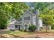 Side view of this two-story home with a well-maintained yard, featuring a charming covered porch and a two-car garage at 802 Bluff Pl, Woodstock, GA 30188