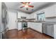 Modern kitchen features white cabinets, hardwood floors, stainless steel appliances, and ample counter space at 802 Bluff Pl, Woodstock, GA 30188