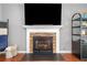 Living room fireplace with stone accents, wooden mantle, and mounted television for cozy ambiance at 802 Bluff Pl, Woodstock, GA 30188