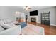 A modern living room with a fireplace, hardwood floors, neutral decor, and an adjacent dining area at 802 Bluff Pl, Woodstock, GA 30188