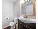 A powder room with a dark wood vanity, vessel sink, and a decorative mirror at 802 Bluff Pl, Woodstock, GA 30188