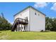 Back exterior view of a white home with a wooden deck with stairs surrounded by a green lawn at 25 Running Terrace Way, Cartersville, GA 30121